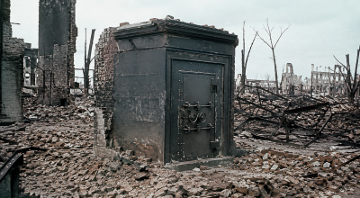 Salle des coffres d'une banque restée intacte au milieu des ruines après une catastrophe, illustrant la résistance des chambres fortes face aux tempêtes, incendies et conflits.